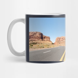 Yellow lines down middle of road through desert Mug